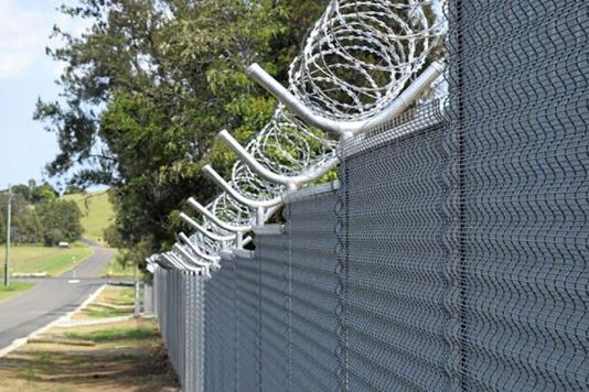 Колючий дріт на металевому паркані