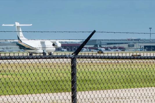 Аеропорт, колючий дріт, паркан і літак