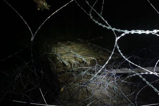 Колючий дріт та дерев'яні щити