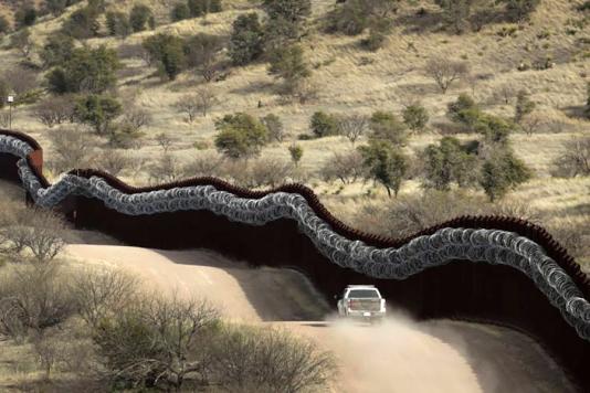 Пограничная стена с колючей проволокой