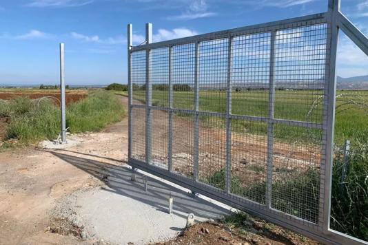 Ворота в паркані з колючого дроту