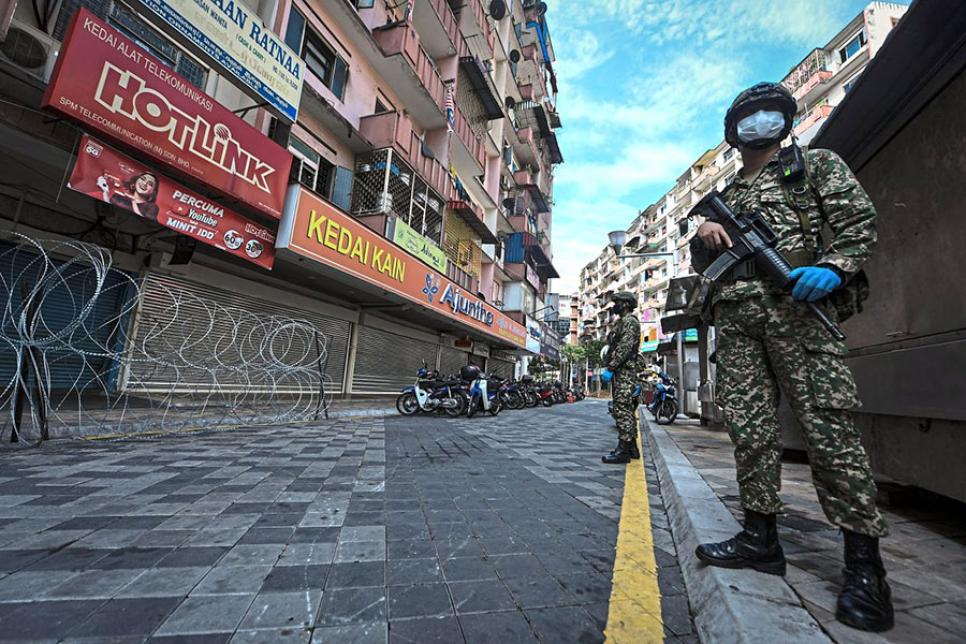 Колючий дріт та озброєні військові в Малайзії