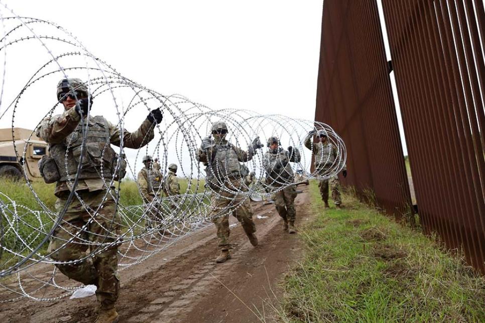 Монтаж колючей проволоки на Стену Трампа