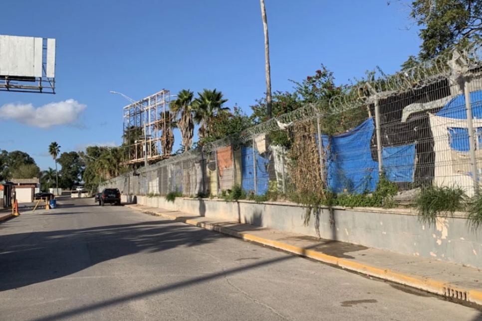 Палаточный лагерь мигрантов за колючей проволокой в Мексике